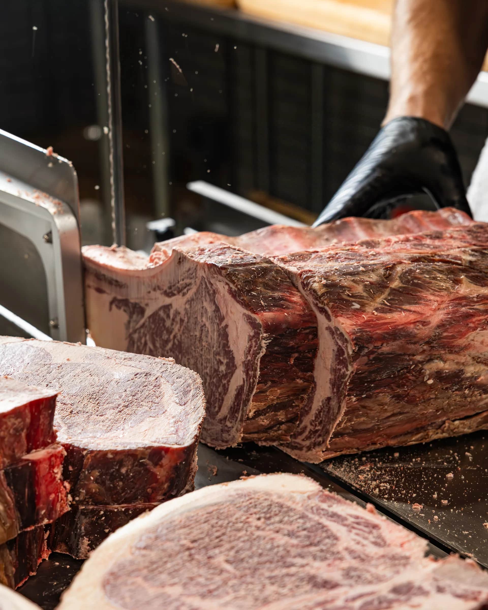 Band saw cutting a dry-aged loin
