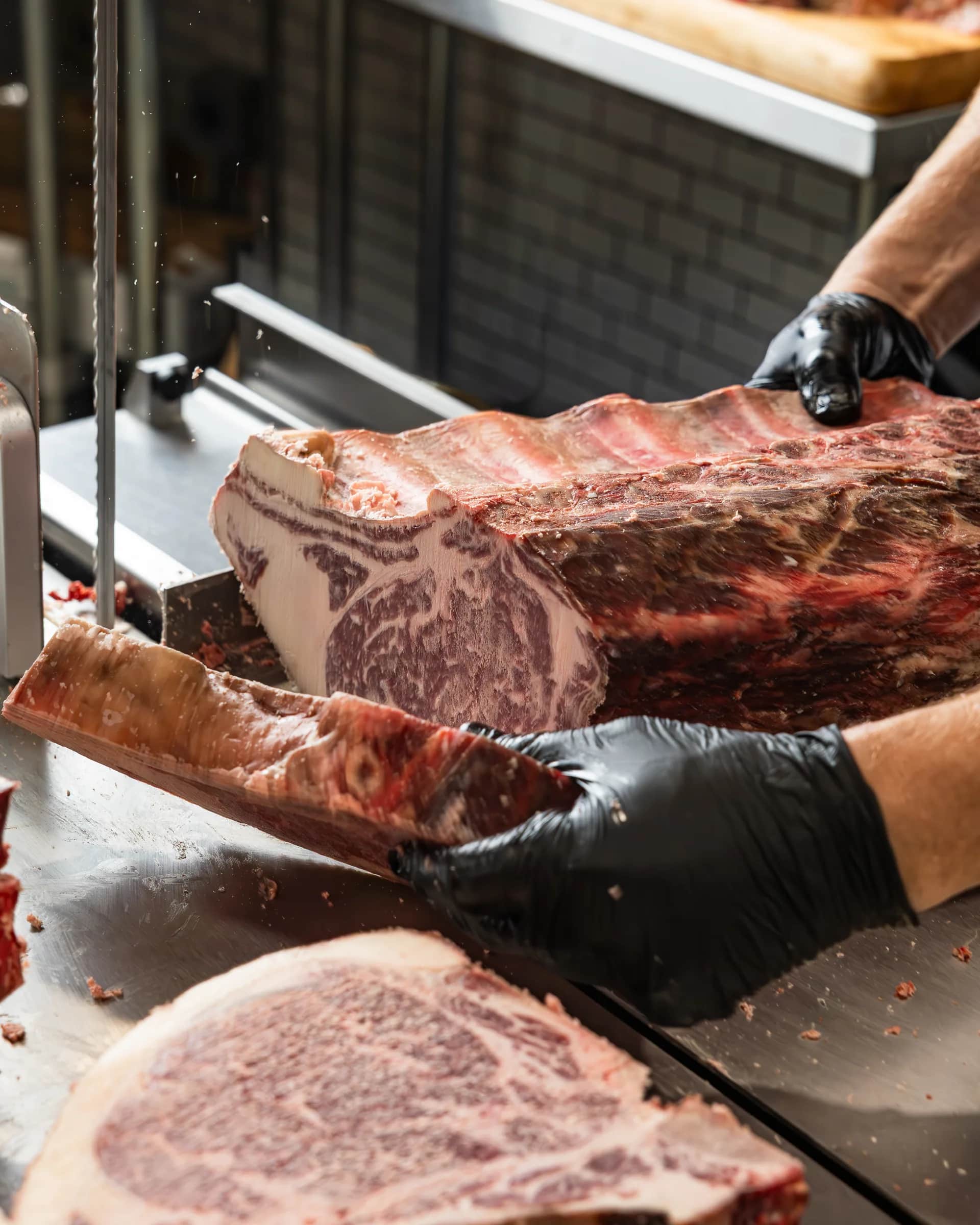 Band saw slicing a marbled ribeye